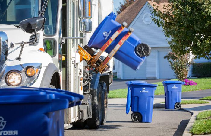 A recycling truck picking up recycling bins.